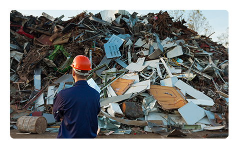 Man in Orange Helmet and Blue Uniform in Front of Dump.